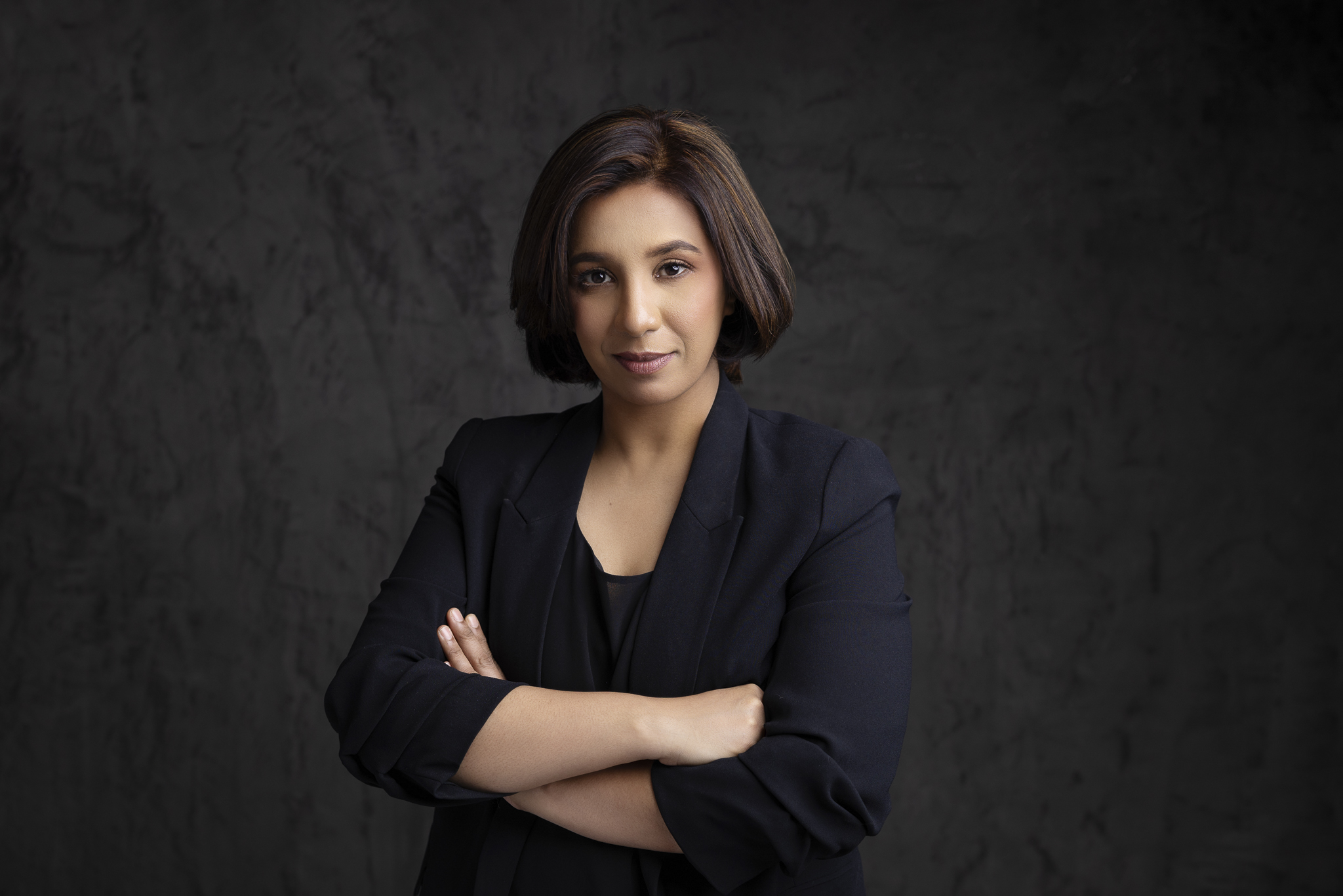 Professional business portrait of a woman with crossed arms.
