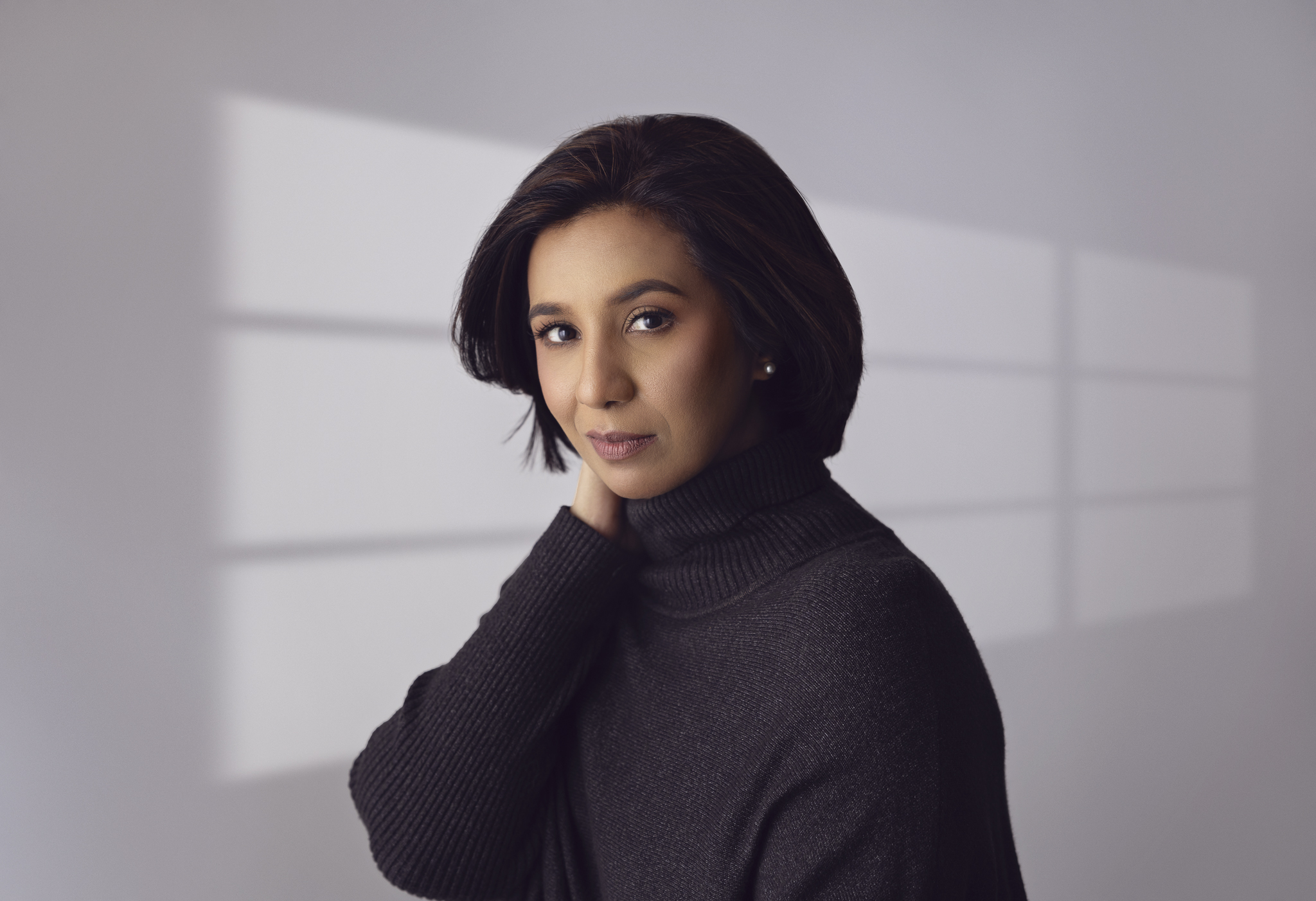 Portrait of a woman with window lighting pattern in the background