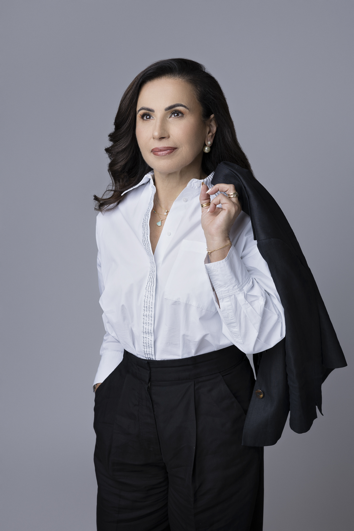 Businesswoman in black suit and white shirt posing for her professional photo in the studio. Doha, Qatar